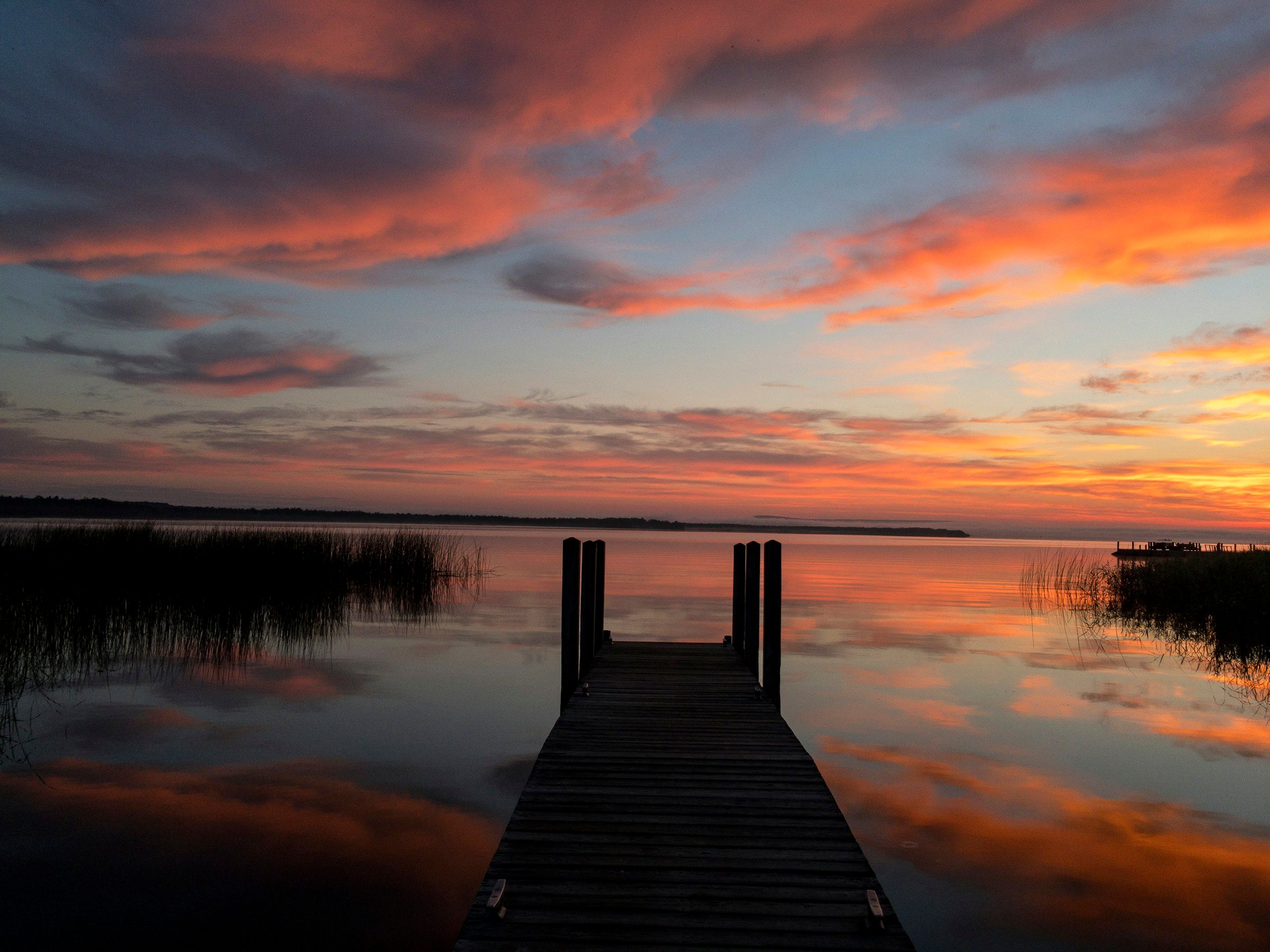 Wooden dock on a calm lake at sunset